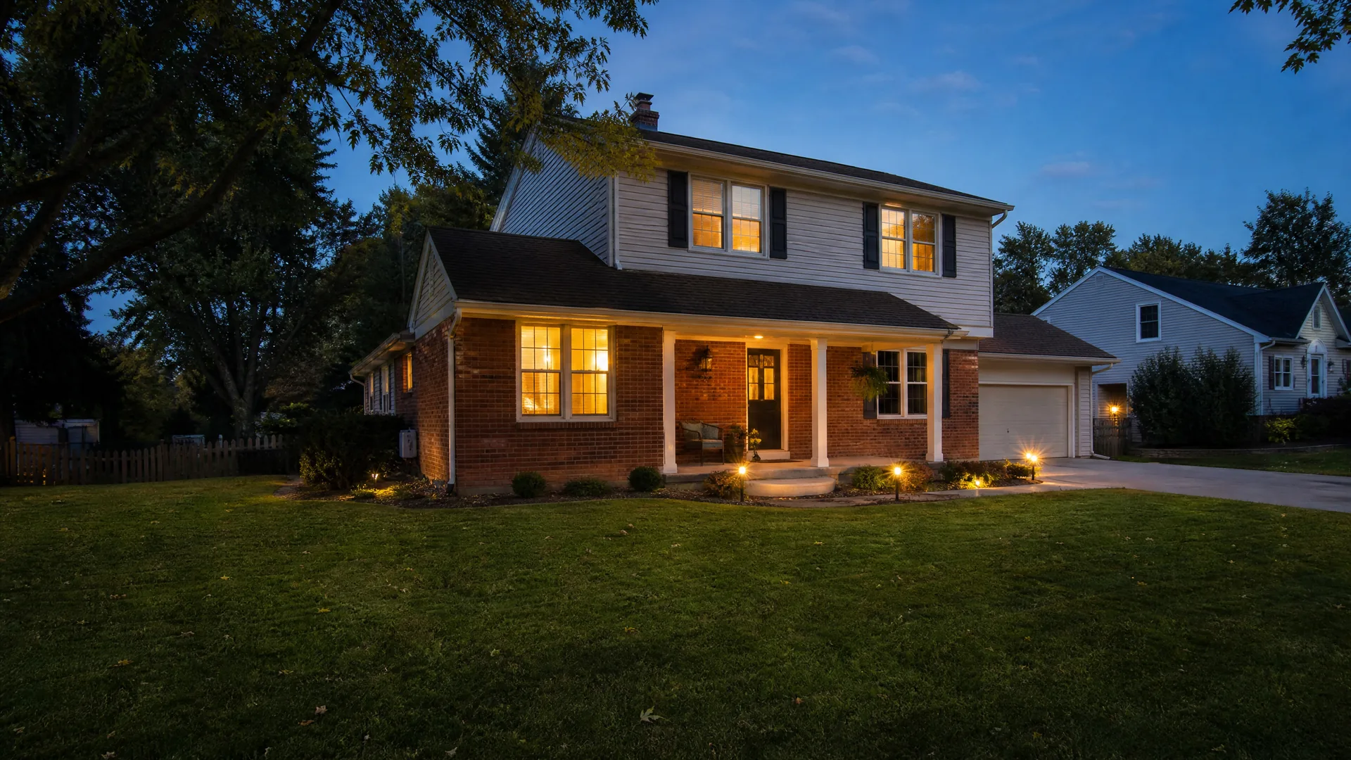 Well-lit Missouri home at dusk with landscape lighting installed by Freedom Electric