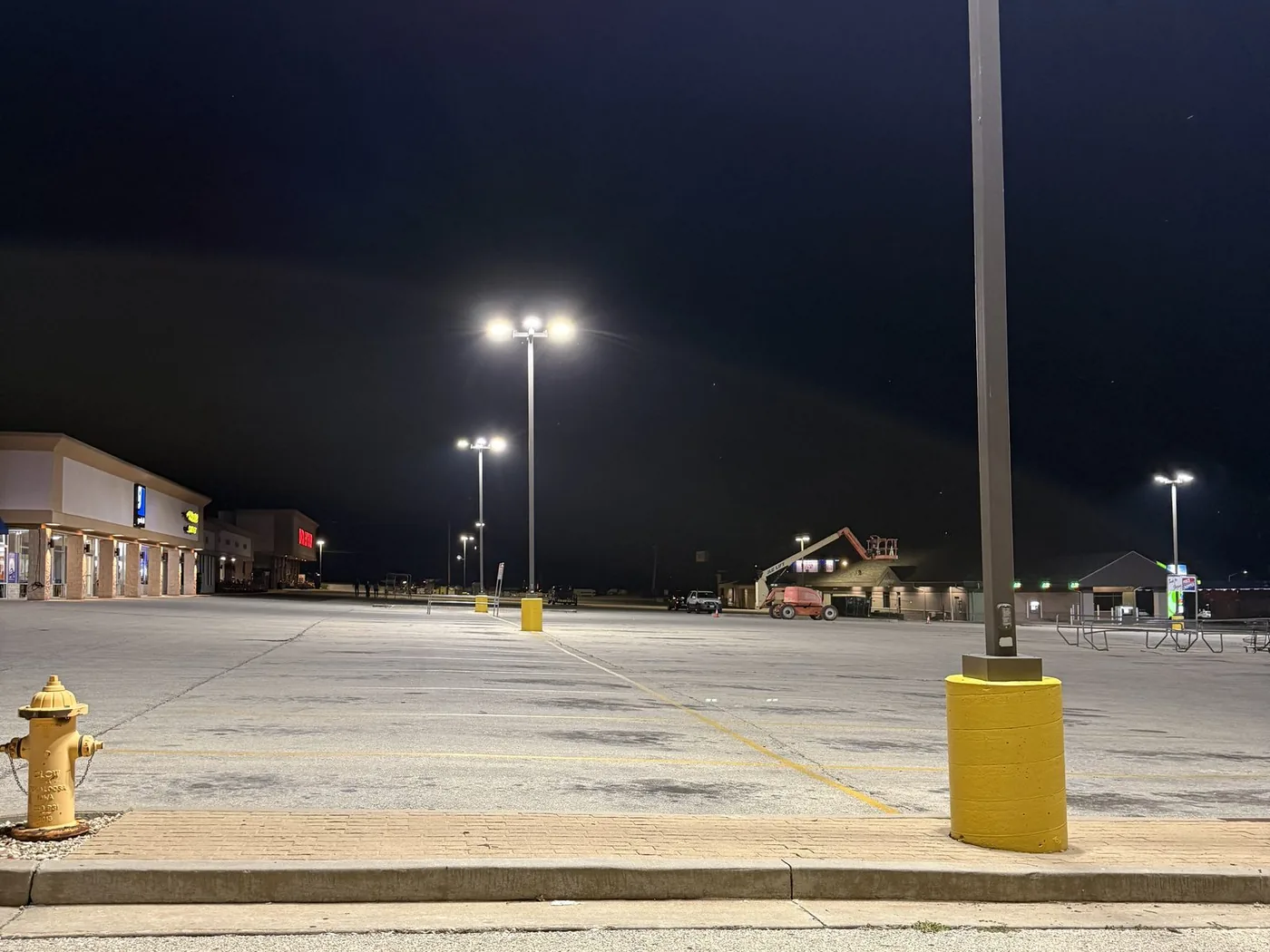 Commercial parking lot pole lighting installed by Freedom Electric with a boom lift on site in Rolla MO